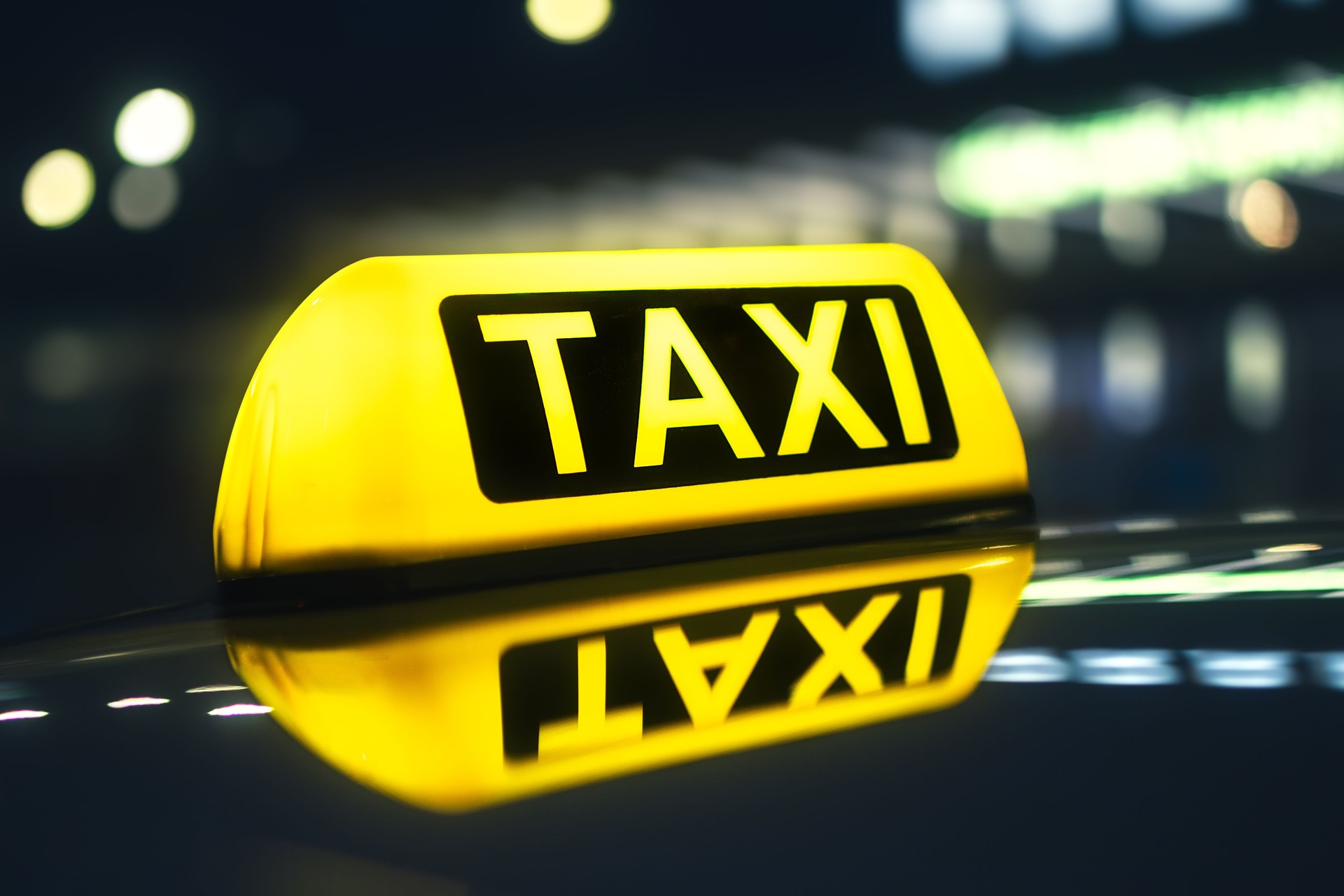 Close-up of taxi sign on car at night